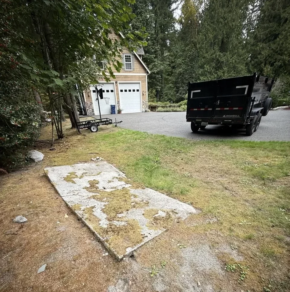 Concrete slab beside a lawn before demolition in Redmond