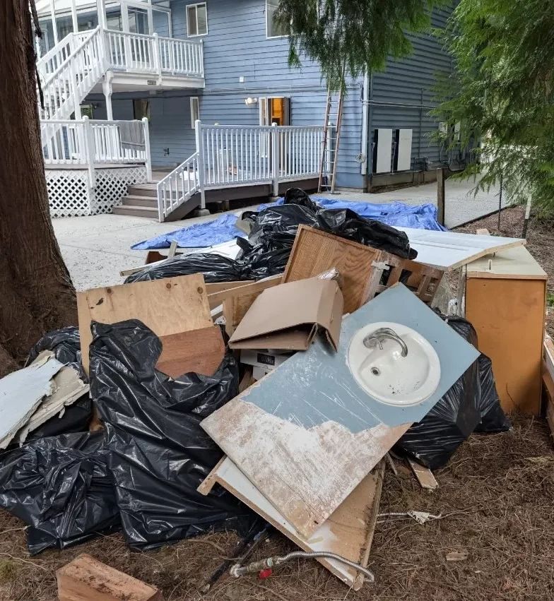 Cabinets, sink, drywall and bagged remodel debris awaiting removal in Woodinville